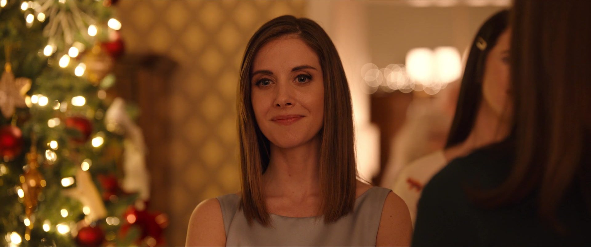 A woman at a holiday party, lit warm