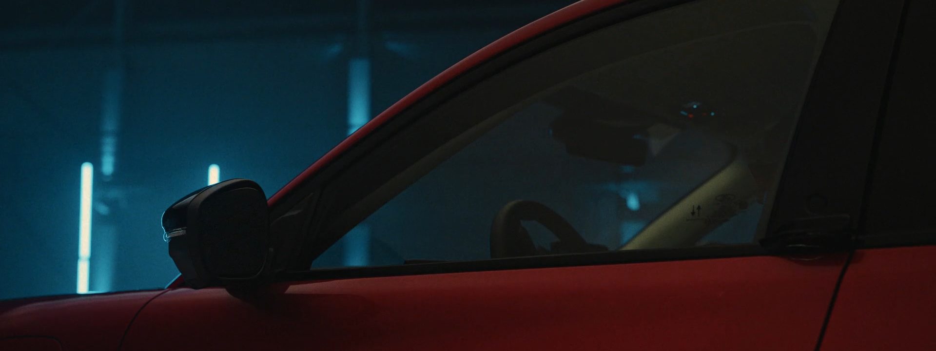 Red bodywork and glass under cool light