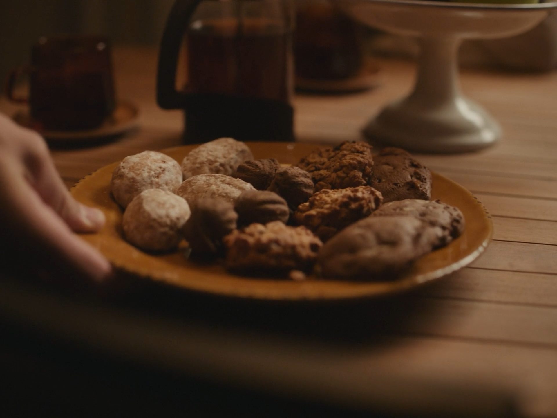 A plate of cookies being set down