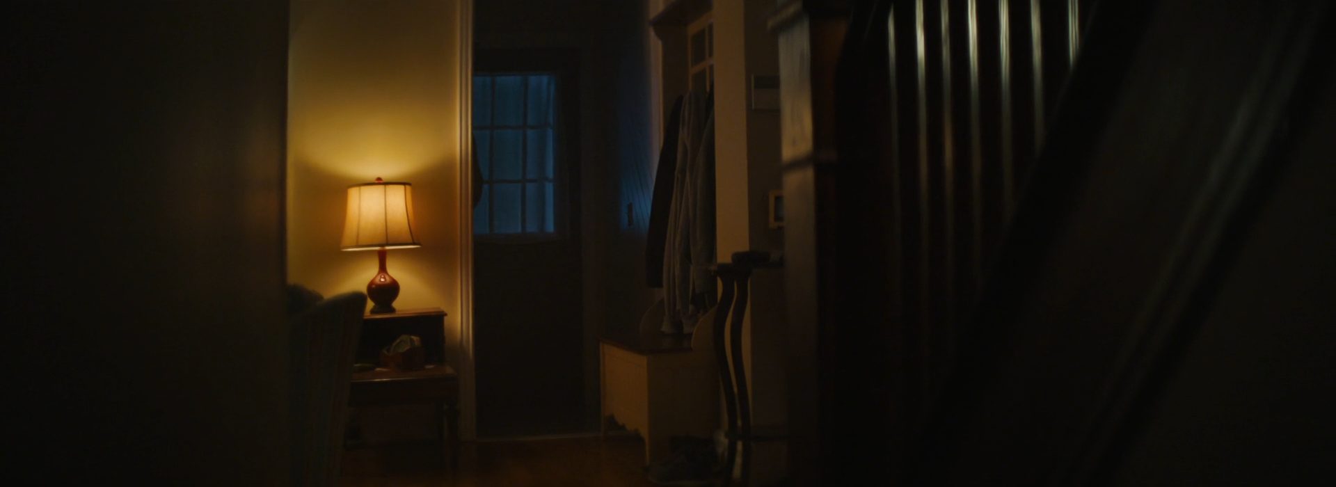 A hallway lit warm, with cool night at the window beyond